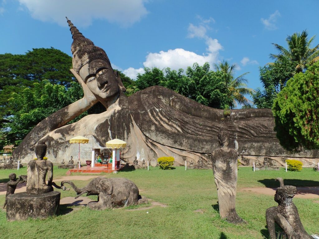 Buddha park, a large buddha statue laying on it side.